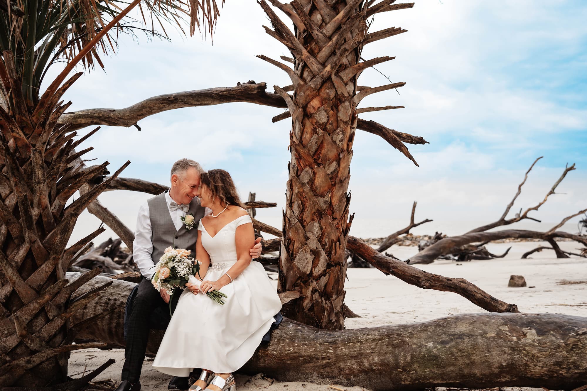 Bride and groom sitting on beach